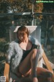 A woman sitting on a chair wearing a fur coat.