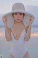 A woman in a white bathing suit and a white hat.