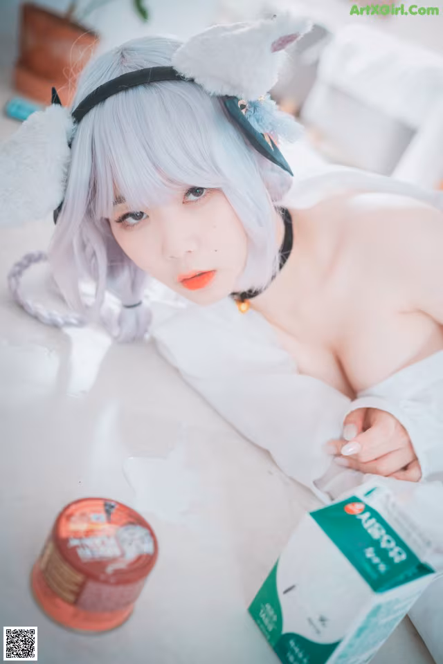 A woman laying on a bed next to a box of milk.