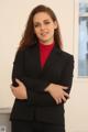 A woman in a black suit standing with her arms crossed.