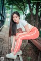 A woman sitting on a bench in a park.