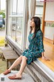 A woman sitting on a bench in front of a window.