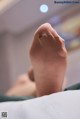 A close up of a person's foot on a bed.