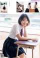 A young woman sitting at a desk in a classroom.