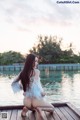 A woman sitting on a dock by the water.